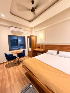 a hotel room with a bed and a table and chairs at Rishaan Regency in Silchar +13 photos