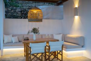 a dining room with a table and chairs and a couch at Archipelago Sifnos - Seaside Accommodation in Vathi