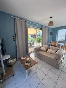 a living room with a couch and a table at La Petite Maison Bénance in Sarzeau
