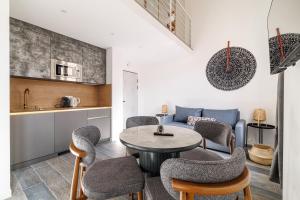 a kitchen and a living room with a table and chairs at Maison Astéria in Nice