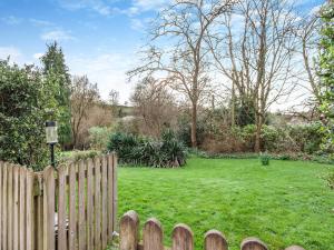a wooden fence in front of a yard with a field at Midsummer Cottage Retreat in Pilton
