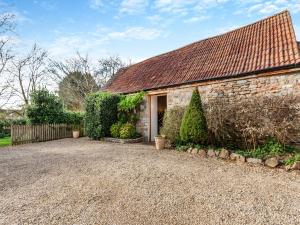 a brick house with a door and a gravel driveway at Midsummer Cottage Retreat in Pilton