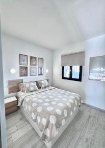 a white bedroom with a large bed and a window at Maspalomas Lago 36 in Maspalomas +13 photos