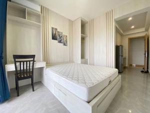 a white bedroom with a bed and a chair at Jitendra Pyakuryal in Kathmandu