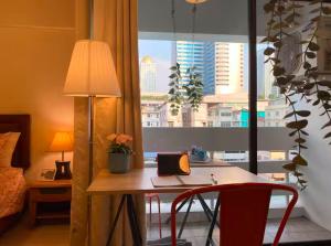 a bedroom with a desk with a laptop computer on it at Bangkok Prime Location Residence in Makkasan