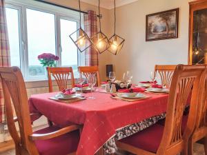 a dining room table with a red table cloth at Seven Seasons in Caldercruix