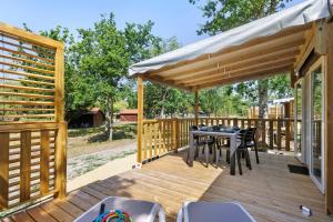 a wooden deck with a table and chairs on it at Mobilehome Vallon 57 in Saint-Gervais