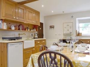 a kitchen with a table with wine glasses on it at Cam Cottage in Kettlewell