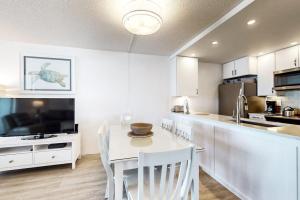 a white kitchen with a table and chairs and a television at Pyramid 4G in Ocean City +13 photos