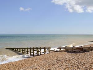 a wooden pier on a beach near the water at Petit Knowle in Cuckfield +2 photos