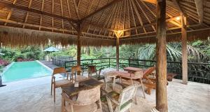a patio with a table and chairs and a pool at Amara Giri Ubud View Villas in Ubud