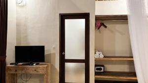 a room with a door leading to a bedroom with a television at Amara Giri Ubud View Villas in Ubud