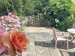 a patio with two chairs and a table and flowers at Sweet Briar - 8234 in Bridport +5 photos