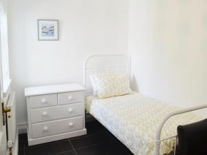 a small bedroom with a bed and a dresser at Sweet Briar - 8234 in Bridport