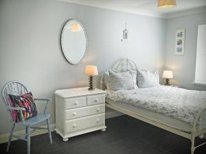 a bedroom with a bed and a chair and a mirror at Sweet Briar - 8234 in Bridport