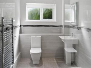 a white bathroom with a toilet and a sink at Sweet Briar - 8234 in Bridport