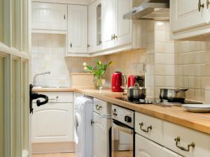 a kitchen with white cabinets and red appliances at Farndale in Pickering