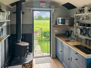 a kitchen with a stove and a door to a yard at Morning Mist in Strensall