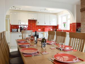 a dining room table with wine bottles and glasses at Rudda Farm House - Uk2491 in Staintondale
