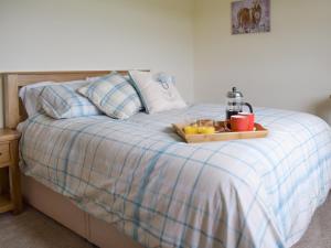 a tray with drinks and oranges on a bed at Rudda Farm House - Uk2491 in Staintondale