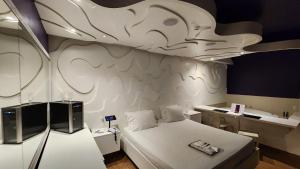 a room with a bed and a desk in it at Tout Motel (Adults Only) in Campinas