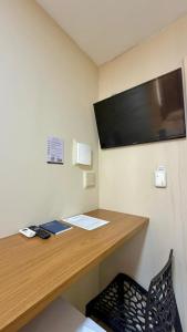a desk in a room with a television on a wall at Hotel Pousada Arco Íris Manaira in João Pessoa