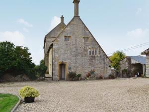 an old stone building with a driveway in front of it at Churchill Cottage in Wootton Glanville