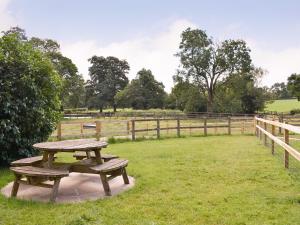 a picnic table in a field next to a fence at Churchill Cottage in Wootton Glanville