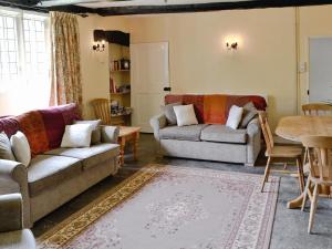 a living room with two couches and a table at Churchill Cottage in Wootton Glanville +3 photos
