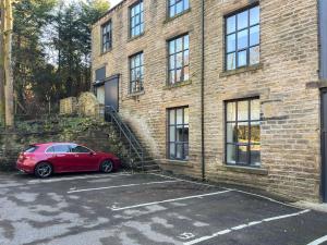 a red car parked in front of a brick building at Green Mill 8 - Uk51369 in Holmfirth