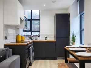 a kitchen with black and white cabinets and a table at Green Mill 8 - Uk51369 in Holmfirth