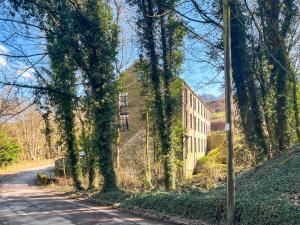 an ivy covered building on the side of a road at Green Mill 8 - Uk51369 in Holmfirth +6 photos