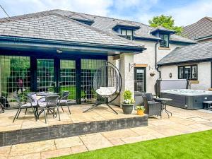 a patio with a table and chairs and a hot tub at Castlebar in Little Singleton