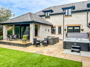 a backyard with a hot tub and a patio at Castlebar in Little Singleton