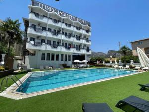 ein Hotel mit einem Schwimmbad vor einem Gebäude in der Unterkunft Three Points Hotel in Beldibi