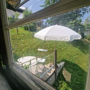 a white umbrella and a chair in a yard at Seelenversteck Oberaichwald in Latschach