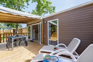a patio with a table and chairs on a deck at Mobilehome Vallon 57 in Saint-Gervais