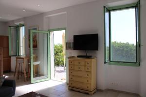 a living room with a television and a dresser with a dresserngthngth at La bastide in Vallauris