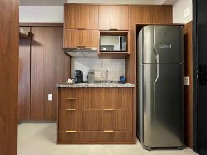 a kitchen with a stainless steel refrigerator and a microwave at On Jurupis - Livinn by Travel Inn OJ1 in São Paulo