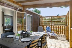 a dining table and chairs on a deck at Mobilehome Vallon 56 in Saint-Gervais