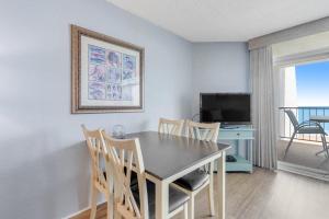 a dining room with a table and chairs and a television at Pyramid 5C in Ocean City