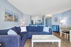 a living room with a blue couch and a table at Pyramid 5C in Ocean City