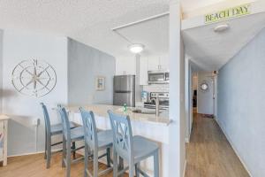 a kitchen with a table and blue chairs in a kitchen at Pyramid 5C in Ocean City