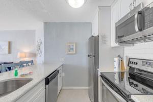 a white kitchen with a sink and a refrigerator at Pyramid 5C in Ocean City +22 photos