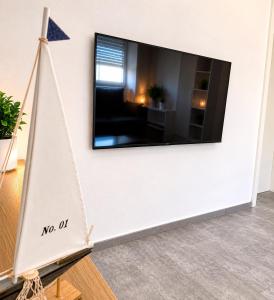 a tv mounted on a wall with a boat in a room at Appartement in Mönchengladbach 2 Zimmer in Mönchengladbach