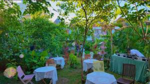 a group of tables and chairs in a garden at 猫とピアノと星空のリゾートブティックコテージ -Starry Forest Cottage Okinawa- in Onna