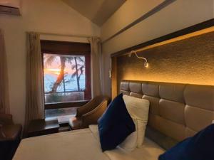 a hotel room with a bed and a window at Kappad Beach Resort in Kappad
