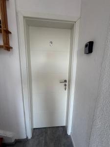 a hallway with a white door with a clock on it at Appartement in Mönchengladbach 2 Zimmer in Mönchengladbach