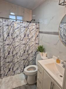 a bathroom with a toilet and a marble shower curtain at La casa de la Playa in Primo Tapia +6 photos