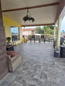 an outdoor patio with tables and chairs and a ceiling at La casa de la Playa in Primo Tapia
